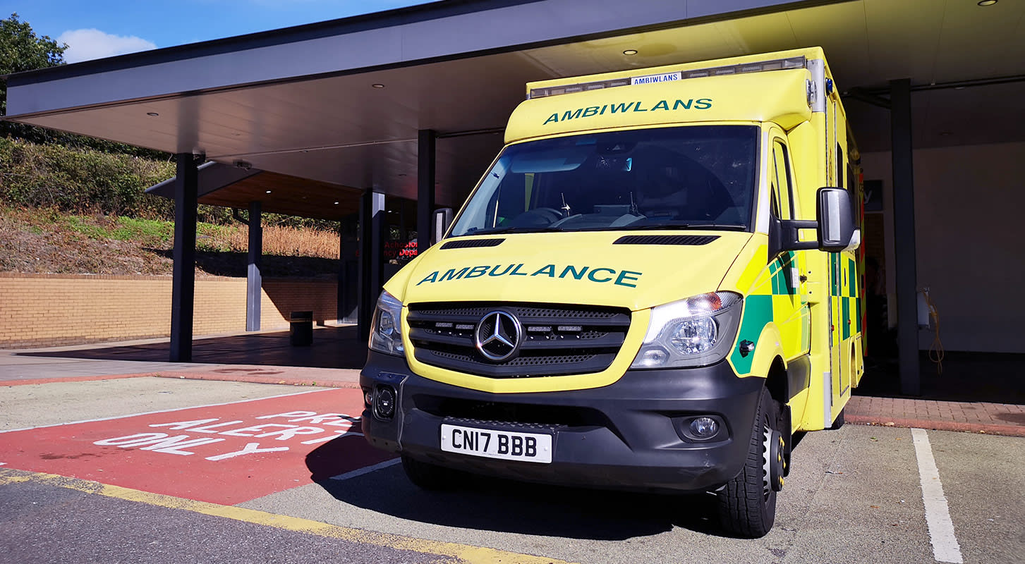 An ambulance parked in front of a medical building, prepared for emergency response.